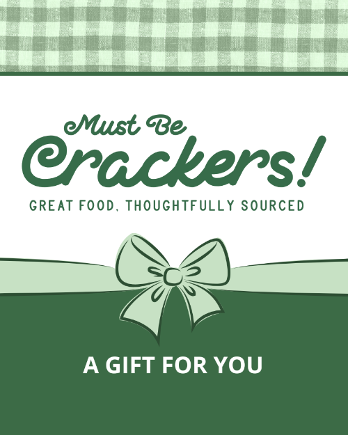 A digital gift voucher for 'Must Be Crackers!' with a green and white checkered pattern, featuring a bow and text that reads 'A gift for you!'.